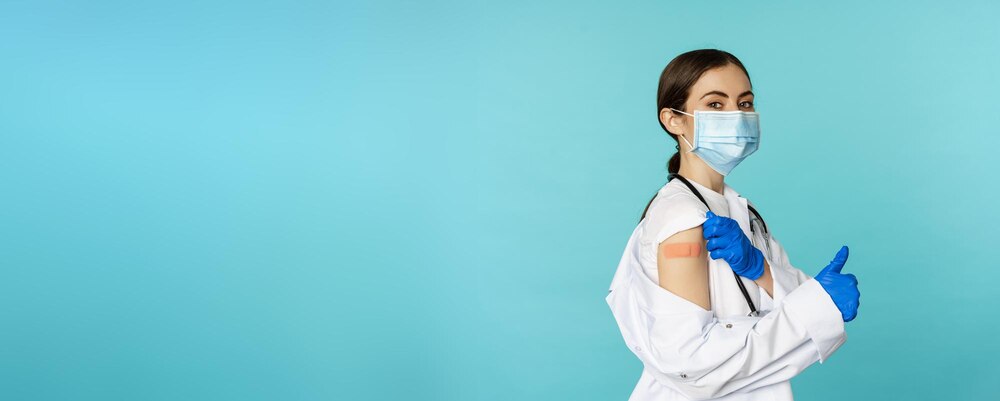 Young female doctor nurse in medical face mask and hospital uniform showing thumbs up after getting